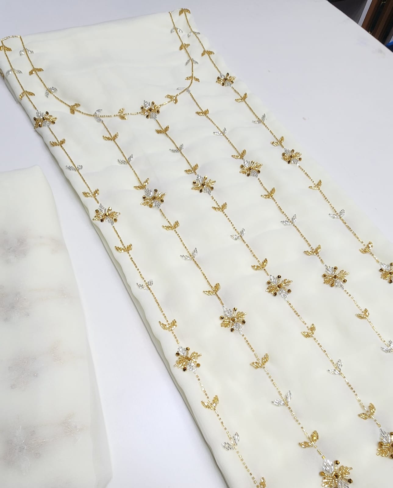 This chiffon dress features an elegant lining and is fully embellished with delicate beading, adding a touch of luxury and sophistication