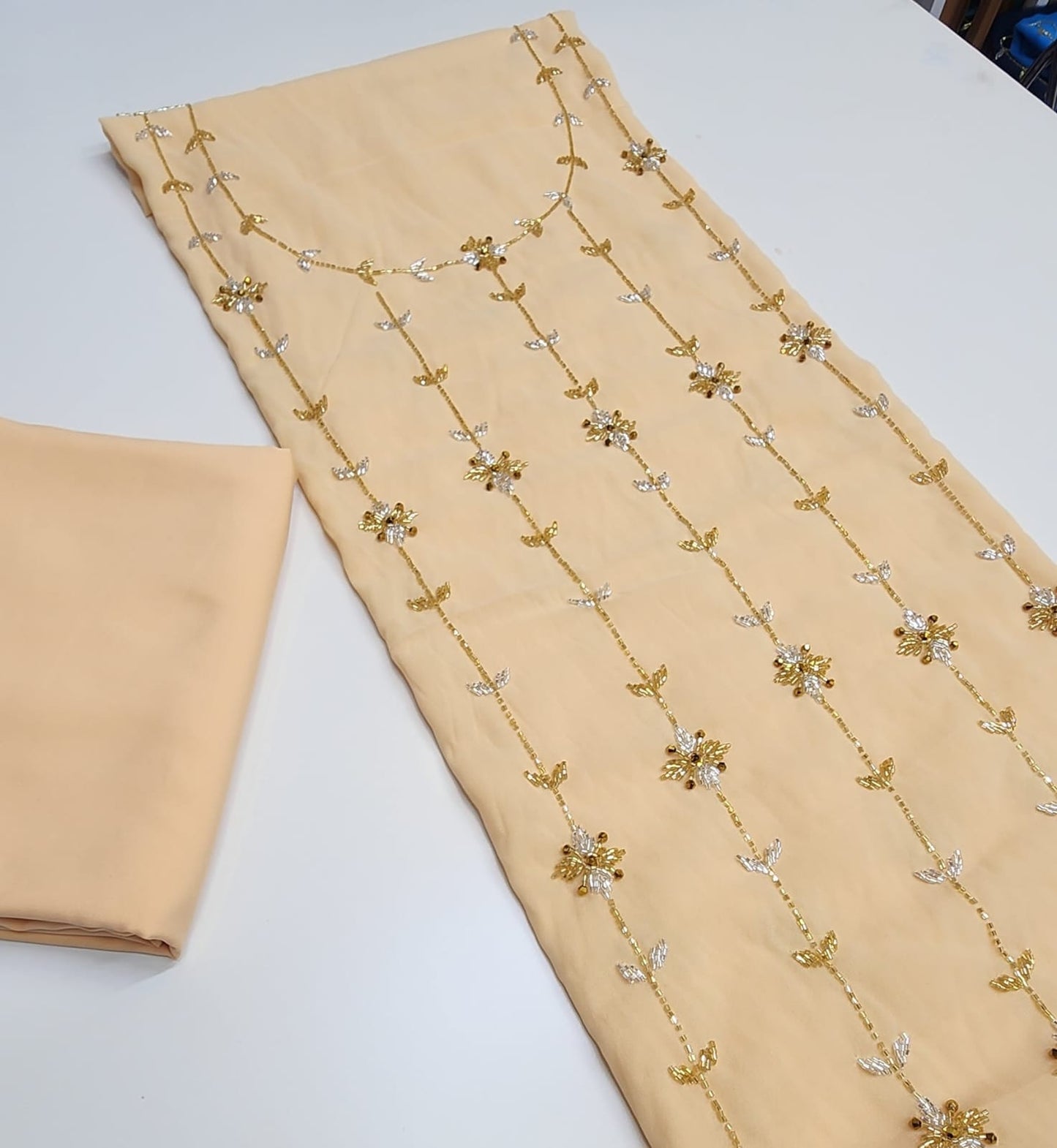 This chiffon dress features an elegant lining and is fully embellished with delicate beading, adding a touch of luxury and sophistication