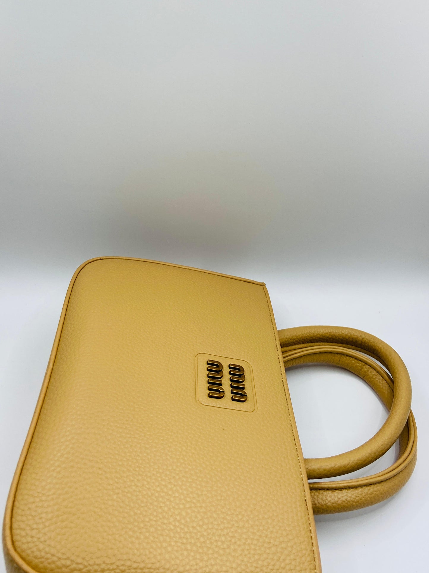 This handbag is a structured, genuine leather tote-style bag designed for modern women who value both elegance and functionality.
