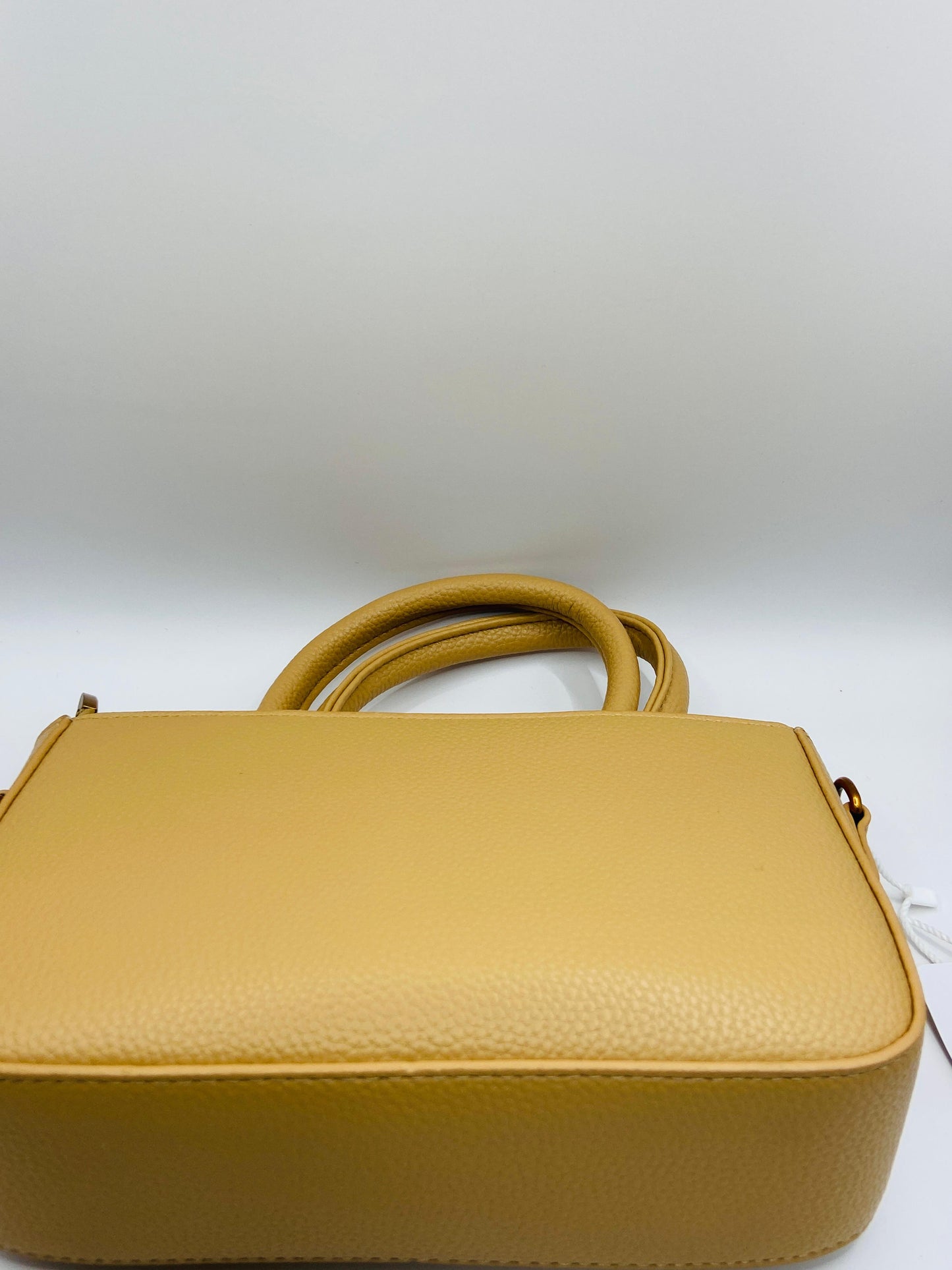 This handbag is a structured, genuine leather tote-style bag designed for modern women who value both elegance and functionality.