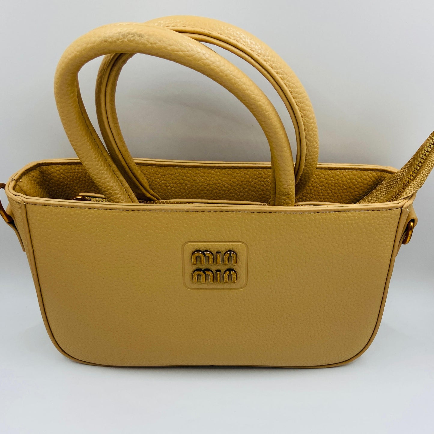 This handbag is a structured, genuine leather tote-style bag designed for modern women who value both elegance and functionality.