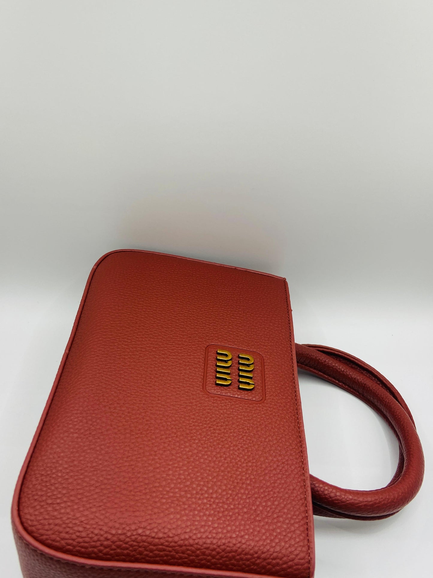 This handbag is a structured, genuine leather tote-style bag designed for modern women who value both elegance and functionality.