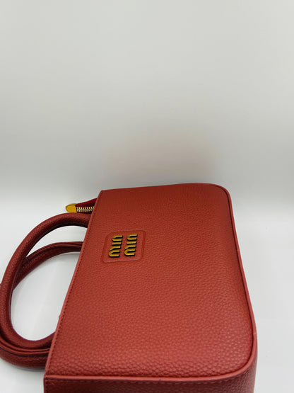This handbag is a structured, genuine leather tote-style bag designed for modern women who value both elegance and functionality.