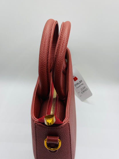 This handbag is a structured, genuine leather tote-style bag designed for modern women who value both elegance and functionality.