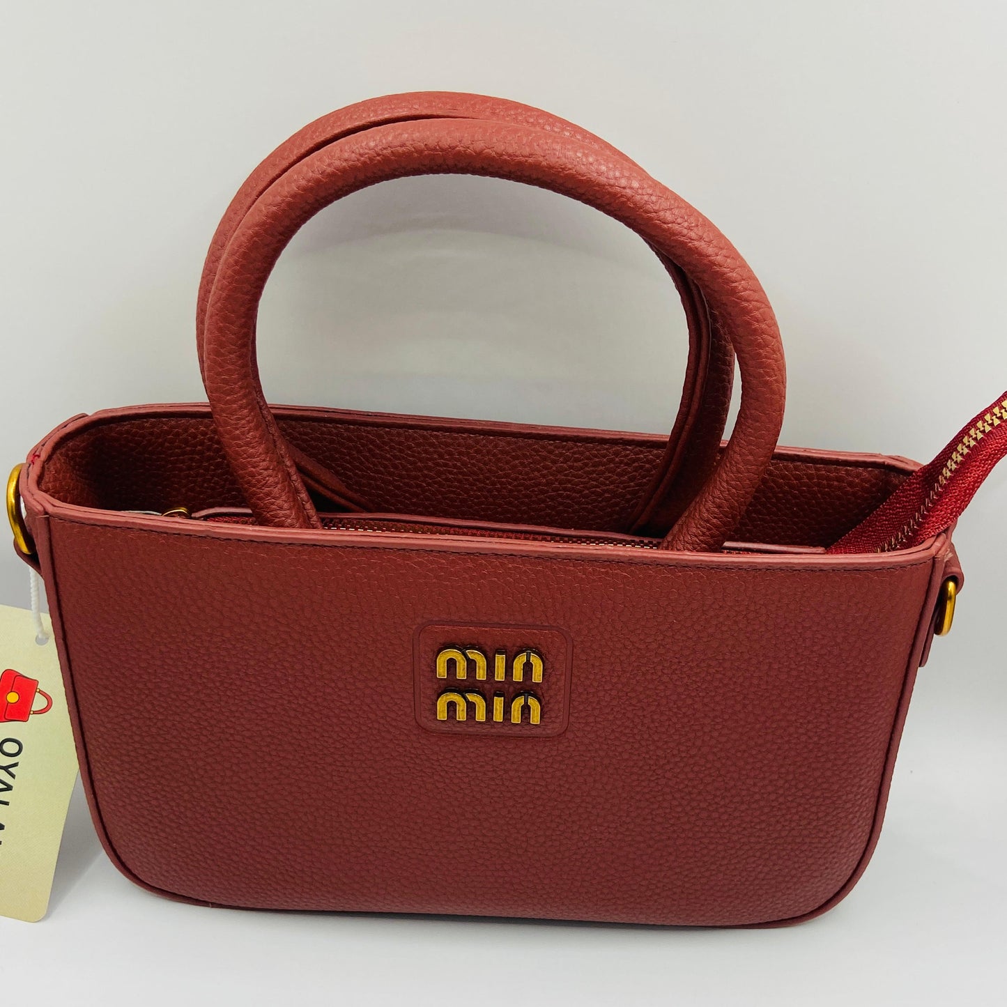 This handbag is a structured, genuine leather tote-style bag designed for modern women who value both elegance and functionality.