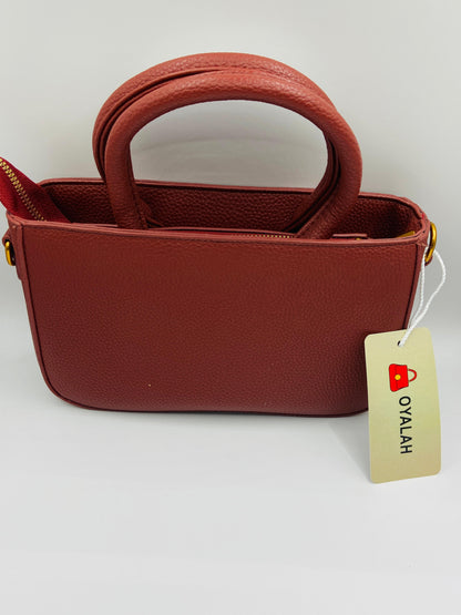 This handbag is a structured, genuine leather tote-style bag designed for modern women who value both elegance and functionality.