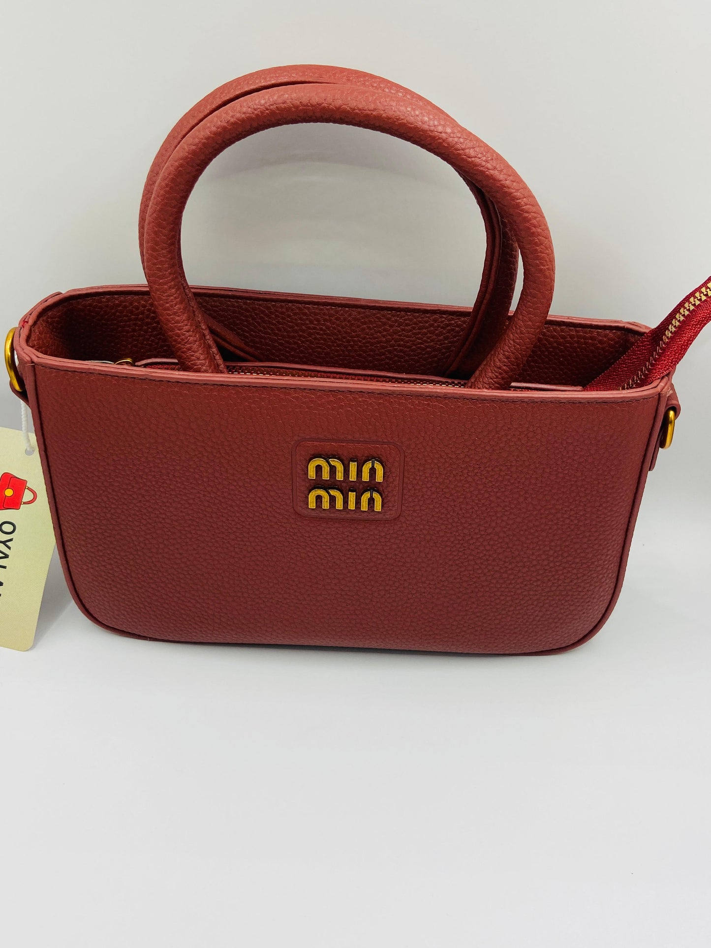 This handbag is a structured, genuine leather tote-style bag designed for modern women who value both elegance and functionality.