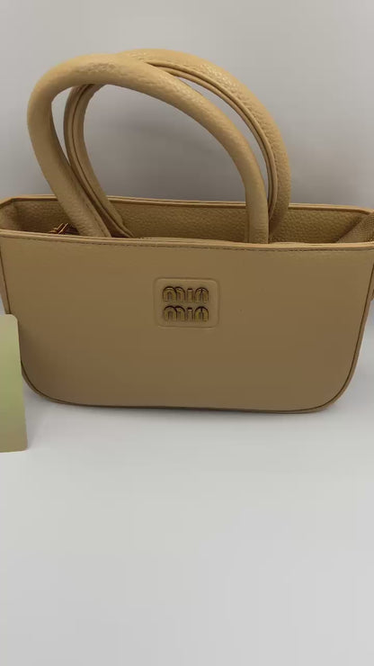This handbag is a structured, genuine leather tote-style bag designed for modern women who value both elegance and functionality.
